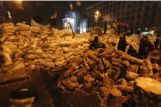 Pro-European integration protestors sit on barricades in Independence Square in Kiev